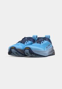 Chaussures de trail de course bleu clair avec un dessus texturé, des accents bleu foncé, une semelle Vibram et des panneaux en maille pour la respirabilité.