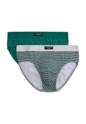 Dos calzoncillos tipo slip para hombre, uno verde con un pequeño patrón de triángulos y otro gris con rayas horizontales verdes y negras, ambos con etiquetas de Ysabel Mora.