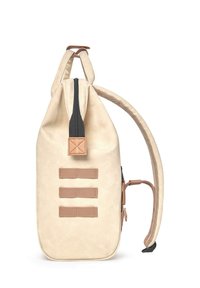 Mochila de lona beige con un zipper negro, acentos de cuero marrón, tres correas horizontales en la parte frontal y una correa de malla en el costado.
