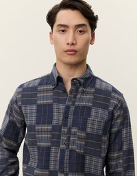 Καρό πουκάμισο με κουμπιά σε σκούρο μπλε και γκρι, που διαθέτει τσέπη και ποικιλία σχεδίων καρό. Φτιαγμένο από πλεκτό ύφασμα με απαλό υφή.