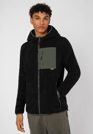 Schwarze Fleece-Haube mit einer grünen Brusttasche, durchgehendem Reißverschluss und kontrastierenden Reißverschlussdetails; verfügt über einen strukturierten Stoff und eine Kapuze.