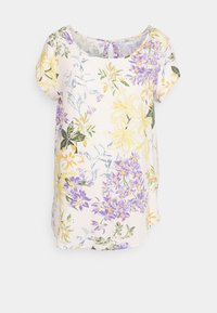 Bloemmotief kortemouwblouse in crème, met gele, paarse en groene bloemen. Ronde halslijn met een sleutelgatdetail aan de achterkant.