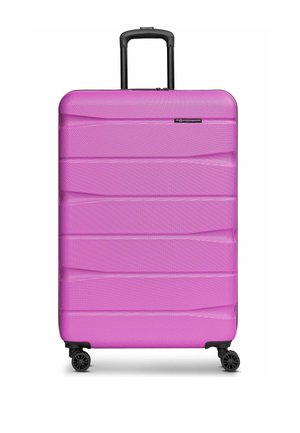 Grande valise rigide rose avec surface texturée, quatre roues noires pivotantes et poignée télescopique noire étendue.
