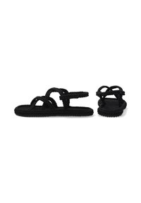 Zwarte touwsandalen met meerdere gevlochten bandjes en een platte zool. Het ontwerp is open aan de tenen met een minimalistische stijl.