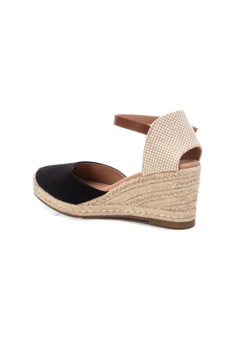 Black suede wedge sandal featuring a woven jute heel and checkered beige fabric back with a brown ankle strap. Closed toe design.