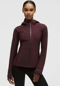 Burgundy huvad jacka i stretchigt material, med dragkedja, sidofickor och tumhål i ärmarna för ökad komfort.