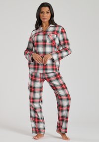 Red, black, and white plaid pajama set with long sleeves, a button front, and a chest pocket. Pants feature an elastic waistband.