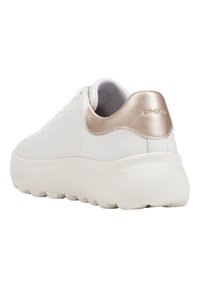 Sneaker blanche avec une tige en cuir lisse, une semelle en caoutchouc épaisse et un accent en rose doré métallique au talon. Présente des détails de couture subtils.
