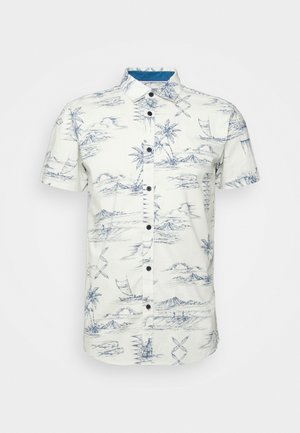 Chemise blanche à manches courtes boutonnée avec un imprimé tropical bleu comprenant des palmiers, des montagnes, des bateaux et des nuages.
