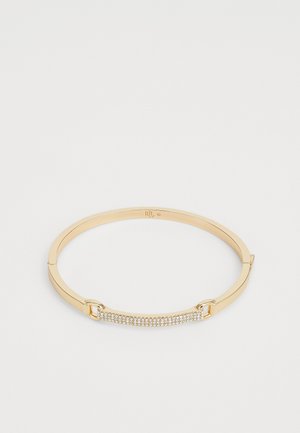 Gouden hinged bangle armband met een rechthoekige staaf bezet met kleine heldere kristallen.