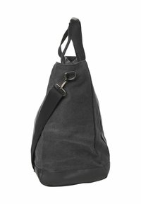 Schwarze Canvas-Reisetasche mit Lederboden und abnehmbarem Schultergurt, aufgehängt vor einem weißen Hintergrund.