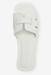 Hvide lædersandaler med flad sål, der har et bredt stropdesign og minimale stikninger. Glat overflade hele vejen igennem.