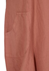 Texturerad, rostfärgad tyg med fickdetalj på vänster sida, som visar en mjuk drapering och mjukhet.