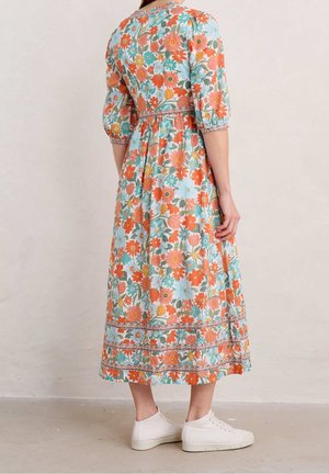Lange bloemenjurk in lichtblauw met oranje, roze en groene patronen. Bevat puffmouwen, een getailleerde bovenkant en een gelaagde rok ontwerpen.