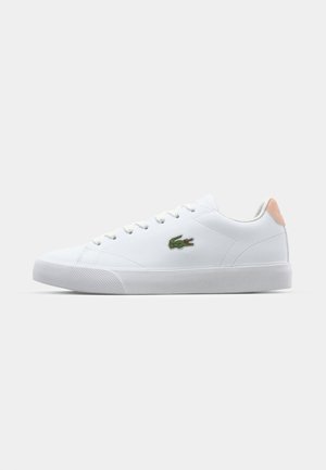 Baskets blanches basses en matériau lisse, avec une semelle en caoutchouc texturé, un logo brodé vert et un accent rose clair sur le talon.