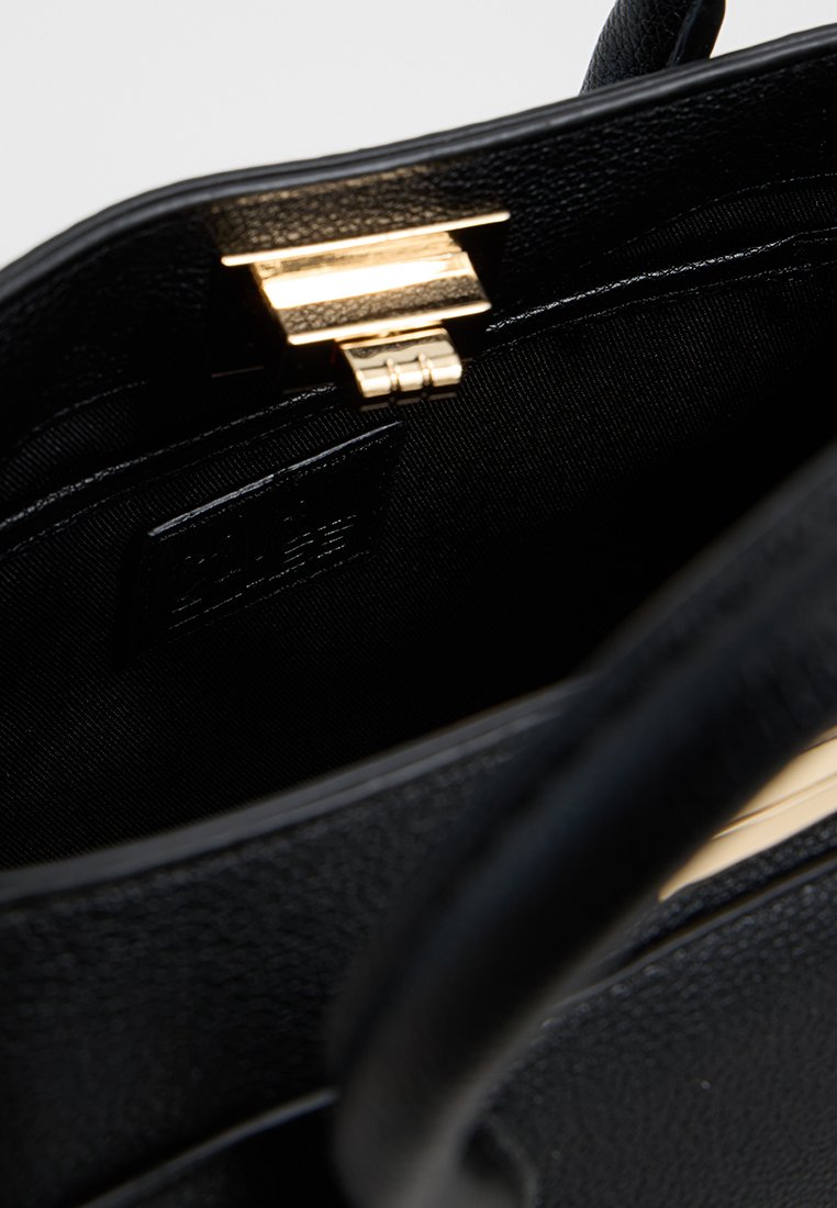 Bolso negro con textura de piel sintética, herrajes en tono dorado y un bolsillo interior con cremallera. Presenta un diseño estructurado y dos asas.