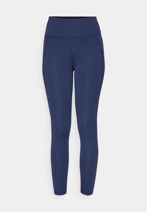 Mørkeblå leggings laget av elastisk stoff, med høy midje og rene sømmer. Tett passform uten ekstra lommer eller dekorasjoner.