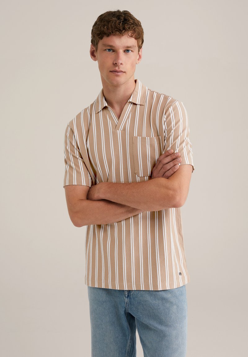 Camisa polo de manga corta en marrón claro con rayas verticales blancas. Cuenta con un escote en V y un bolsillo en el pecho. Hecha de una tela texturizada.