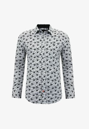 Blouse met lange mouwen en knopen, wit van kleur met een patroon van zwarte abstracte gezichten, voorzien van een opvallende rode knoop vlak bij de onderkant.