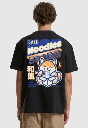 Black cotton t-shirt featuring a colorful graphic of a cartoon dog with noodles and text in multiple languages on the back.