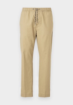 Pantalons beiges avec une taille élastique, un cordon de serrage ajustable, des jambes droites et une texture de tissu léger.