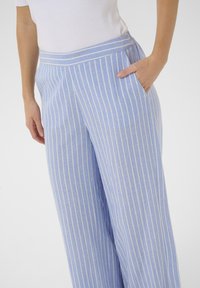Lichtblauwe gestreepte broek gemaakt van zacht materiaal, met een wijdlopend ontwerp, een comfortabele tailleband en een zijzak.
