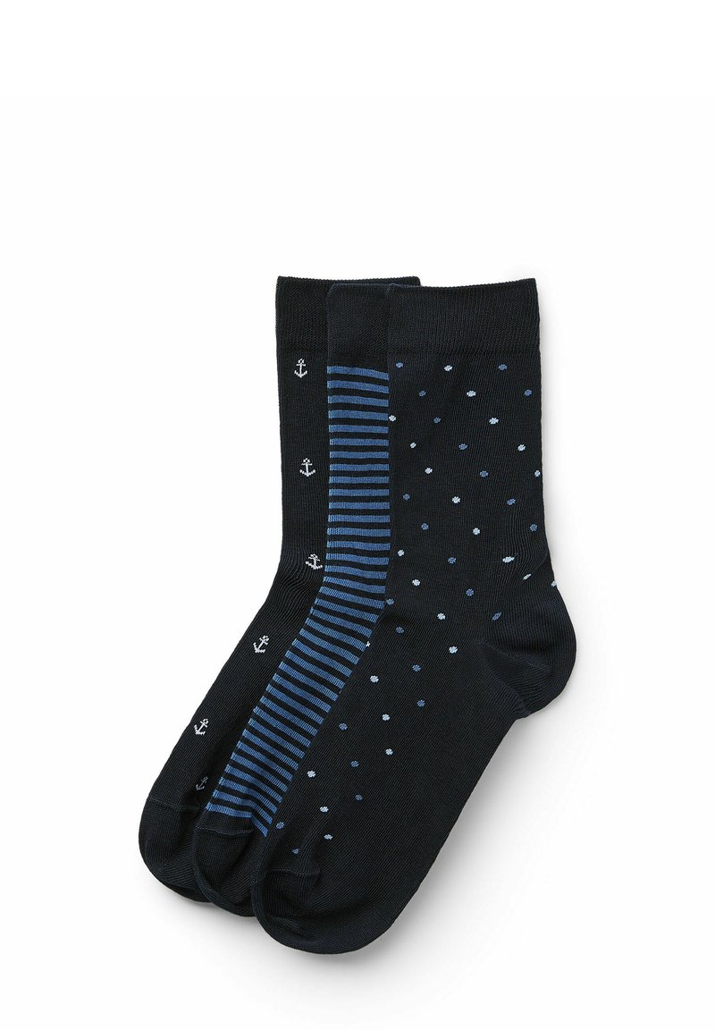 Schwarze Socken, darunter eine mit kleinen weißen Ankern, eine mit blauen Streifen und eine mit blauen Punkten, alle in unterschiedlichen Blautönen.