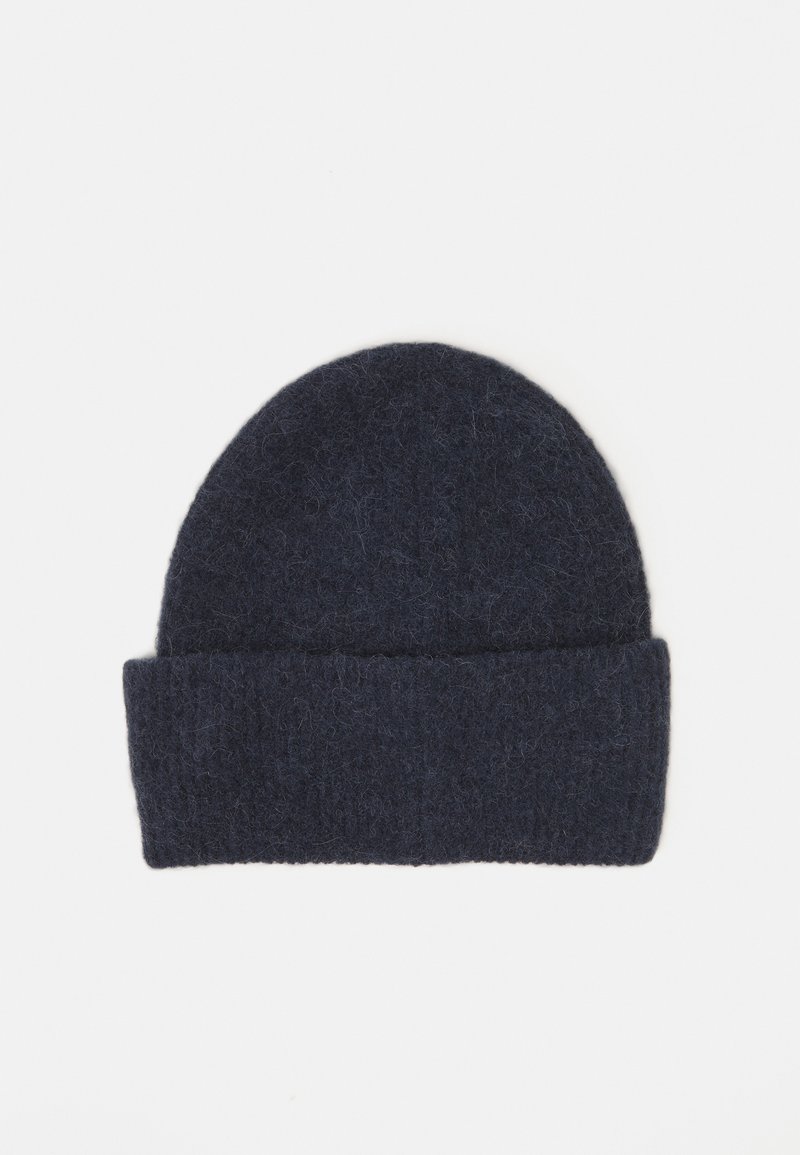Un bonnet en laine bleu marine avec une finition texturée et un revers retroussé. Le chapeau a un sommet arrondi et est fabriqué en matériau doux et duveteux.