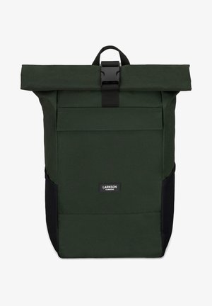 Mochila tipo roll-top en tejido verde oscuro con detalles en negro. Presenta un bolsillo frontal, correa ajustable y etiqueta de marca. Diseño duradero y estructurado.