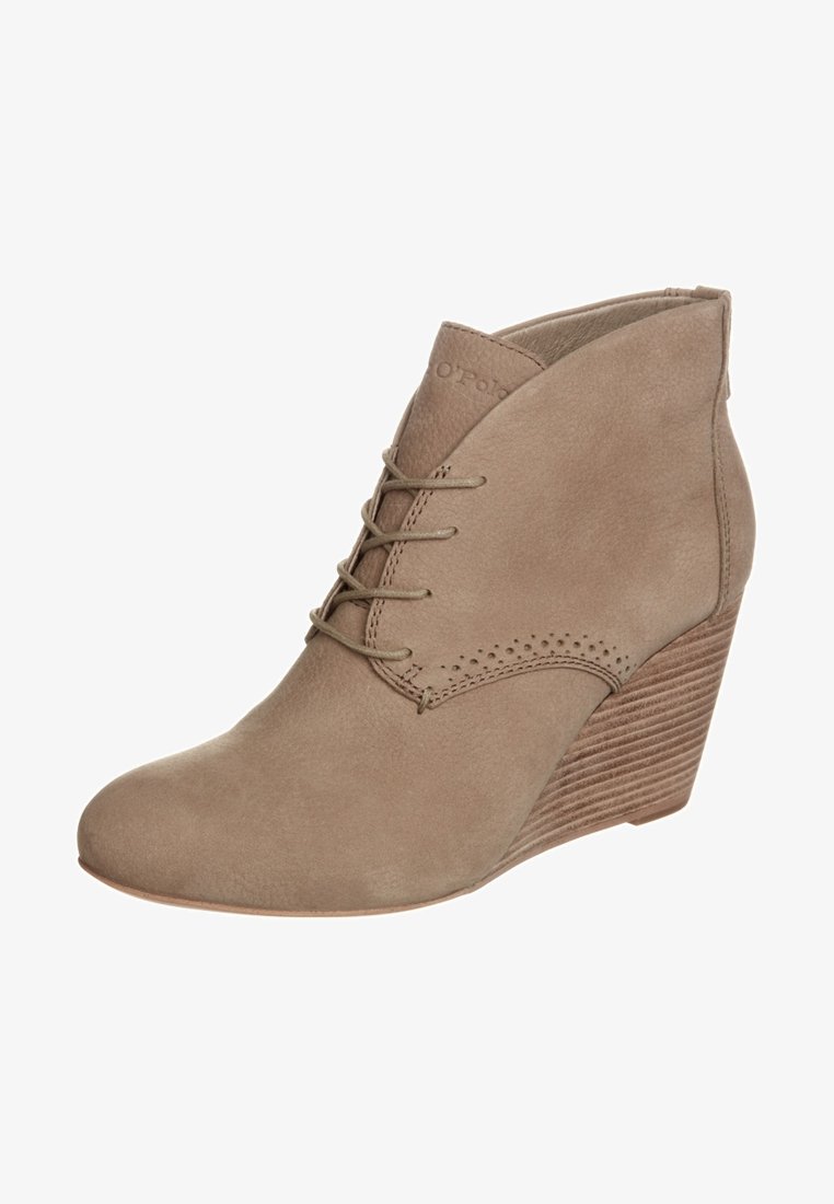 Stivale alla caviglia in camoscio tan con tacco a wedge, lacci, punta tondeggiante, dettagli perforati discreti e design del tacco impilato texturizzato.