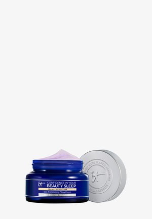 Blauwe pot van "Vertrouwen in je schoonheidsslaap" huid-transformerende kussencrème met zilveren deksel ernaast, met een lichtpaarse crèmetextuur.