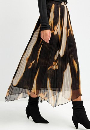 Jupe maxi plissée noire avec des motifs abstraits marron et crème, dotée d'une texture légère et transparente et d'un ourlet ondulé.
