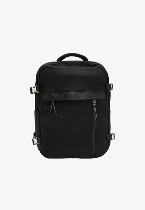 Czarny plecak wykonany z trwałego materiału, o prostokątnym kształcie, z dwoma zamkami błyskawicznymi z przodu, regulowanymi paskami oraz metalowymi akcentami.