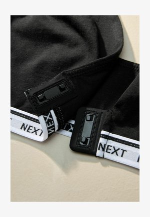 Sorte strækstof hatte med flade sømme og justerbar sort hardware, og med et hvidt mærke bånd med sort skrift i bunden.