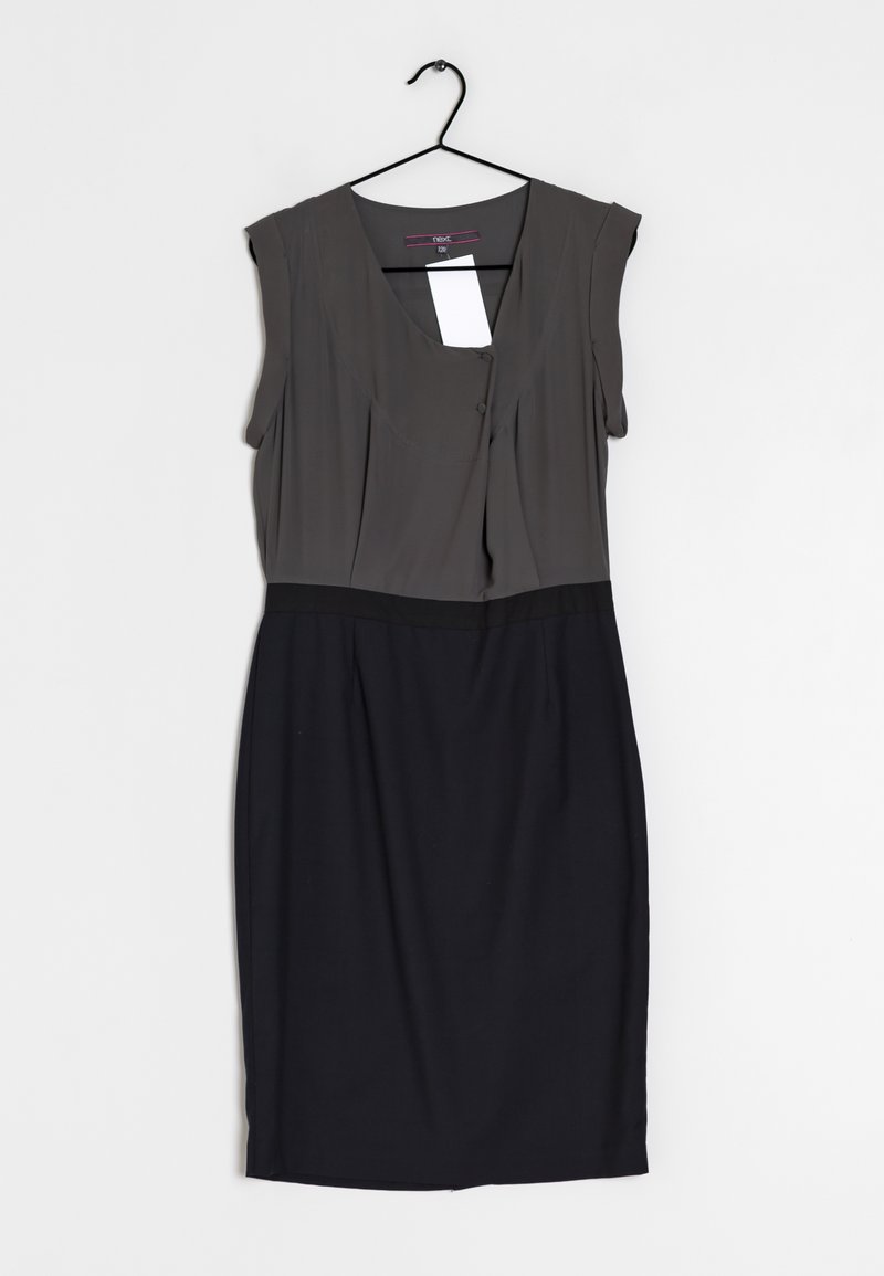 Robe sans manches longueur genou avec haut ajusté gris foncé avec détail de boutons et jupe noire suspendue sur un cintre noir.