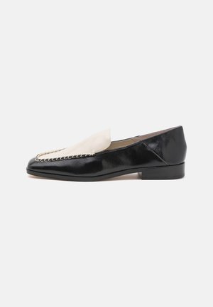 Black leather loafers with a contrasting beige leather top, featuring a stitched detail along the edge and a low heel.