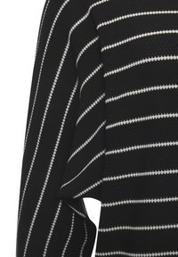 Schwarzer strukturierter Stoff mit gleichmäßig verteilten dünnen weißen horizontalen Streifen, nah aufgenommen und mit Fokus auf einen Ärmel und die Seitennaht.