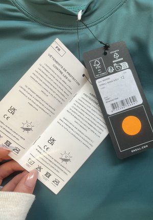 Green O'Neill riided manustega, mis sisaldavad UV-kaitse teavet prantsuse ja itaalia keeles, suurus 12 ning värv Botanical Heat.