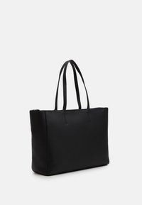 Sac fourre-tout noir en simili cuir lisse. Équipé de deux longues poignées et d'un design rectangulaire minimaliste avec des détails de couture visibles.