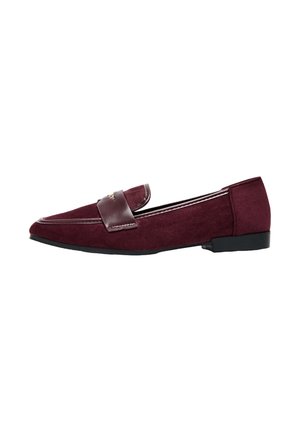 Mocassins en daim bourgogne avec une bandoulière en cuir, à bout pointu et semelle plate en caoutchouc, arborant des surpiqûres le long des bords.