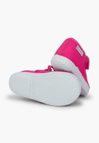 Pantofi sport roz din pânză, cu talpă din cauciuc albă, având o curea cu velcro și detalii texturate pe talpă. Design simplu pentru o purtare ușoară.