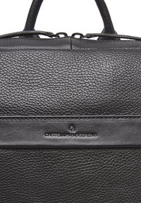 Borsa in pelle nera con finitura testurizzata, manici superiori e logo impresso su un pannello liscio. Chiusura con zip nella parte superiore.