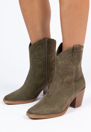 Olijfgroene suède cowboylaarzen met puntige neus, decoratieve stiksels, zijrits en een gestapelde blokhak.