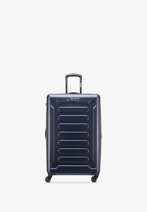 Valigia rigida di colore blu navy, con un design a righe, manico telescopico e quattro ruote per la mobilità. Logo sul davanti.