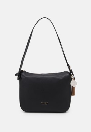 Czarna skórzana torebka na ramię Kate Spade z pojedynczym paskiem, zamkiem błyskawicznym, złotym logo oraz przymocowanym chwostem i białym zawieszkiem w kształcie pik.