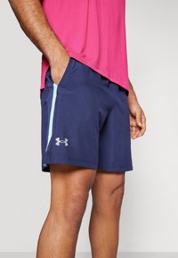 Marina idrottsshorts med ljusblåa sidorand, elastisk midja och fickor. Under Armour-logotyp i silver på vänstra låret.