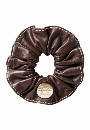 Scrunchie in pelle marrone con texture arricciata e cuciture color crema. Dotato di una placca con logo dorato per l'identificazione del marchio. Forma rotonda.