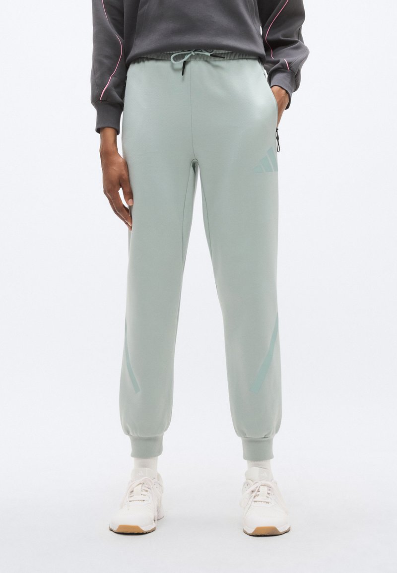 Ανοιχτό πράσινο παντελόνι φόρμας με ελαστικές μανσέτες και ζώνη μέσης, με κορδόνι, πλαϊνές τσέπες και διακριτικό λογότυπο στο πόδι.