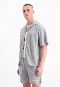 Grijs gemeleerd set met korte mouwen, bestaande uit een overhemd en shorts, met een gestructureerd ontwerp, knoopsluiting en witte geborduurde details.