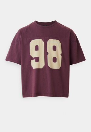 T-shirt en coton bordeaux à coupe décontractée, avec un grand numéro "98" crème imprimé sur le devant. Manches courtes et col rond.